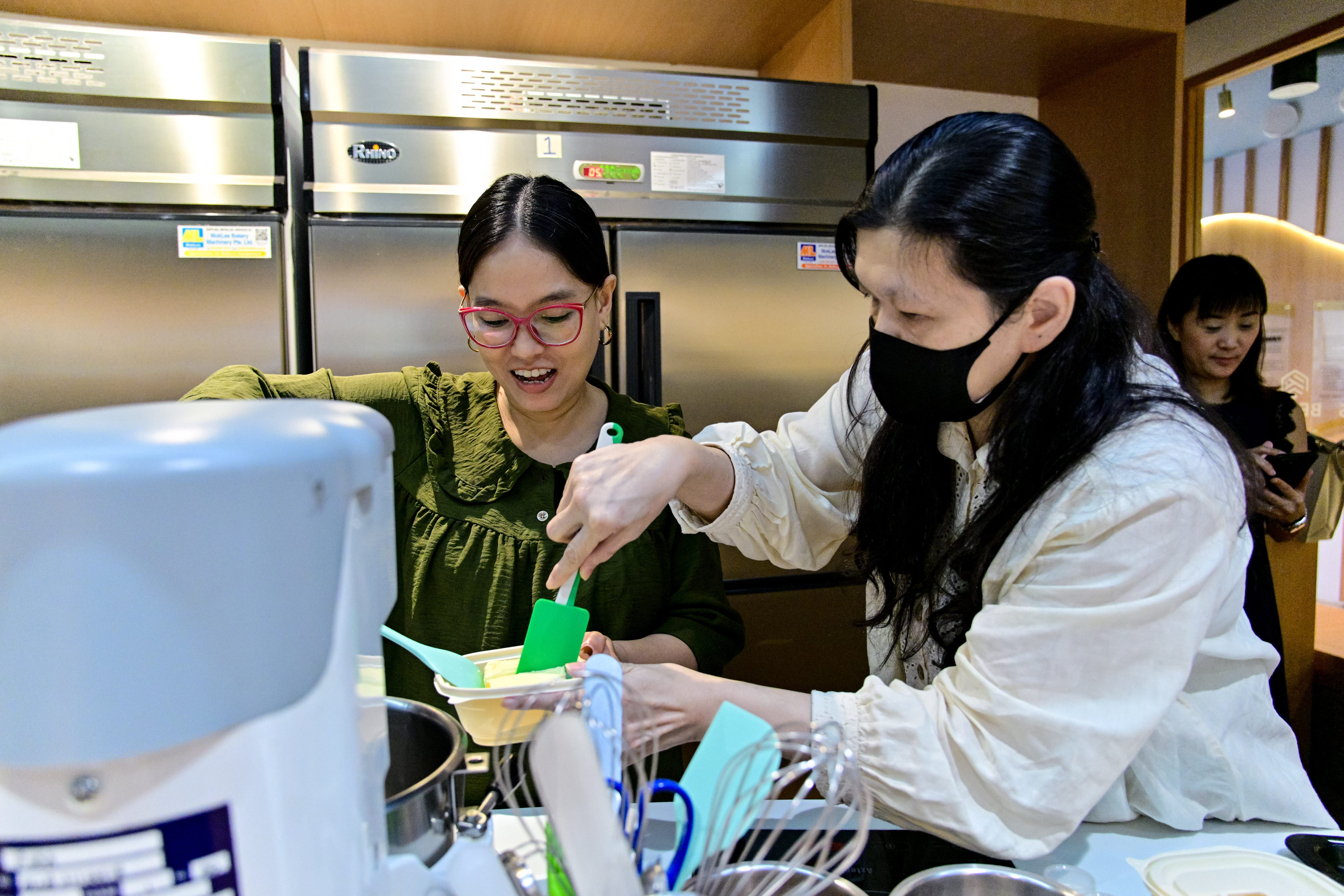 Caregiver supporting an elderly woman in a wheelchair along a sheltered walkway, highlighting community care, assistance, and compassionate support.
